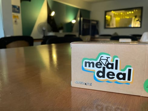 A copy of the card game Meal Deal on a table with soft lighting in the background.