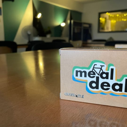 A copy of the card game Meal Deal on a table with soft lighting in the background.